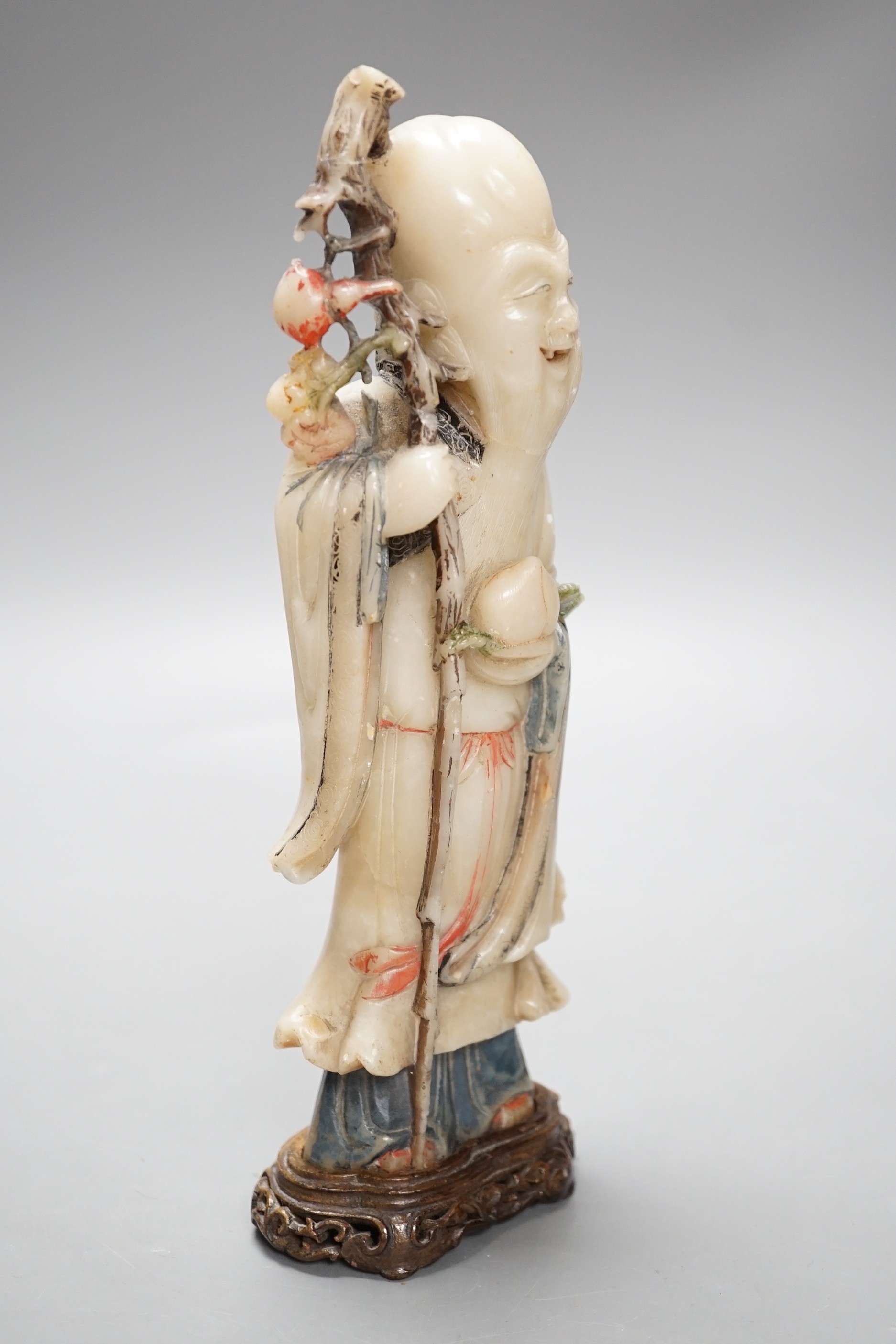 A 18th century Chinese carved soapstone figure of Shao Lou on carved hardwood stand. 24cm high.